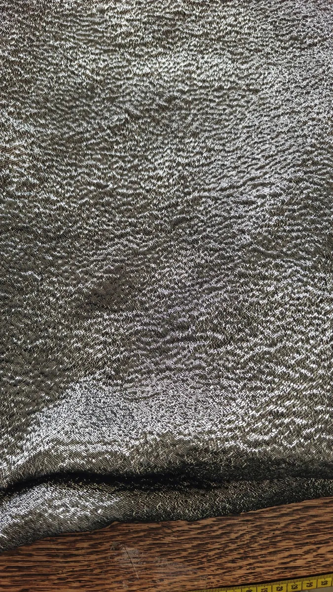 Tissu noir effet lamé à vagues argentées, gros plan sur la texture brillante